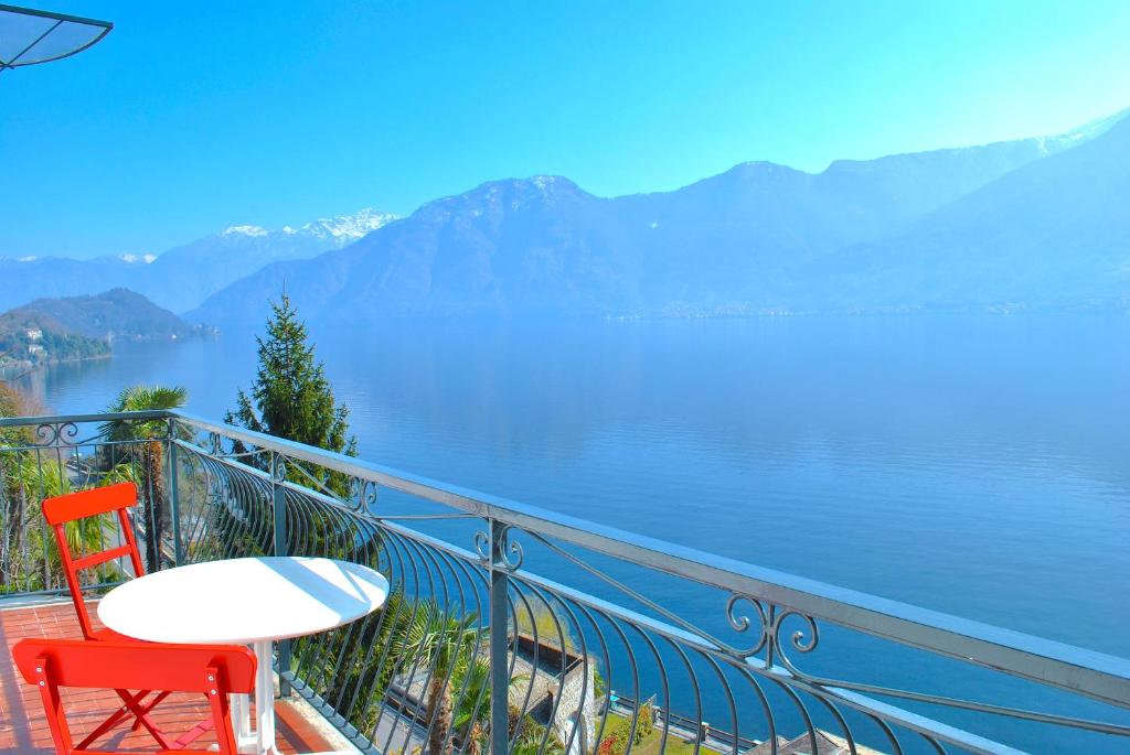 a table and two chairs on a balcony overlooking a lake at Belvedere - Apartment with Balcony Lake View in Sala Comacina