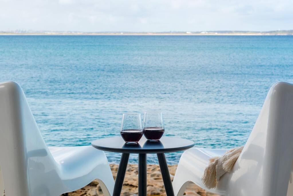 dois copos de vinho sentados numa mesa junto ao oceano em Fogo @ Ethel & Ode’s em Bundeena