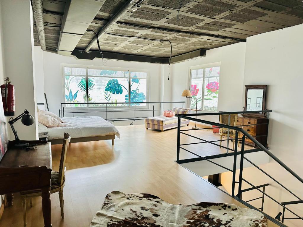 sala de estar con escalera y habitación con cama en LoftSoho, en Alcobendas