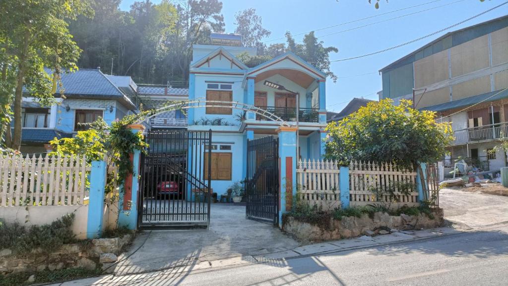 een blauw huis met een hek en een hek bij Homestay Hùng My in Ha Giang