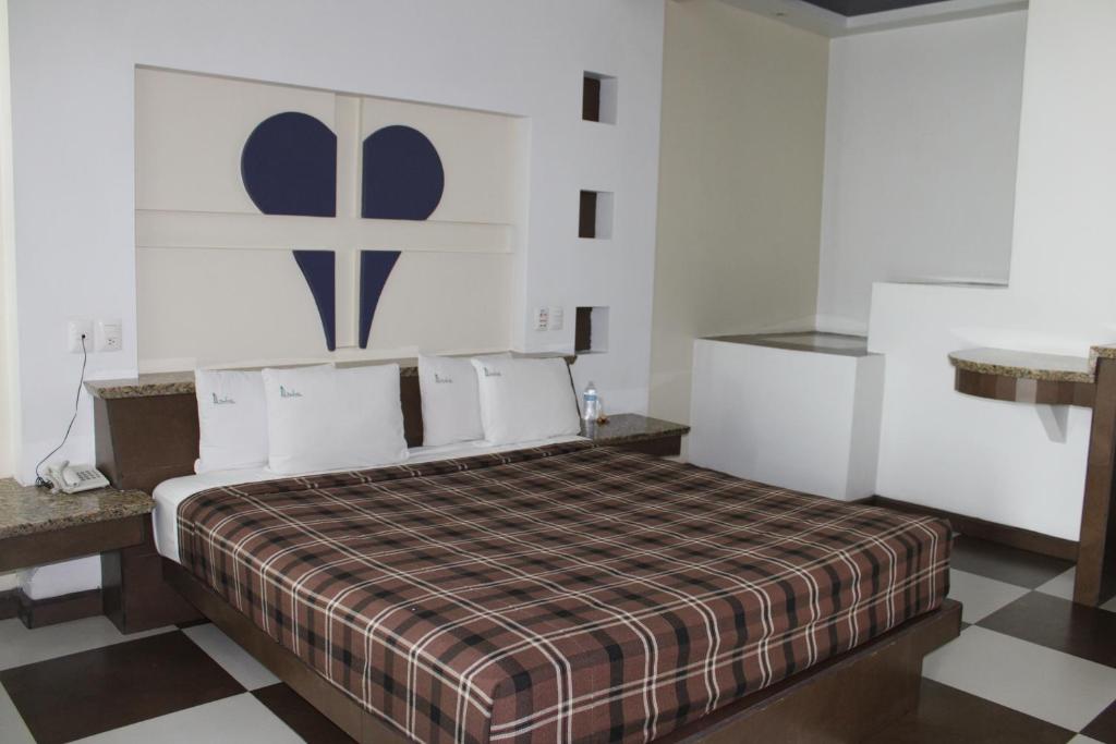 1 dormitorio con 1 cama y suelo a cuadros en Motel Dubái Ensenada en Ensenada