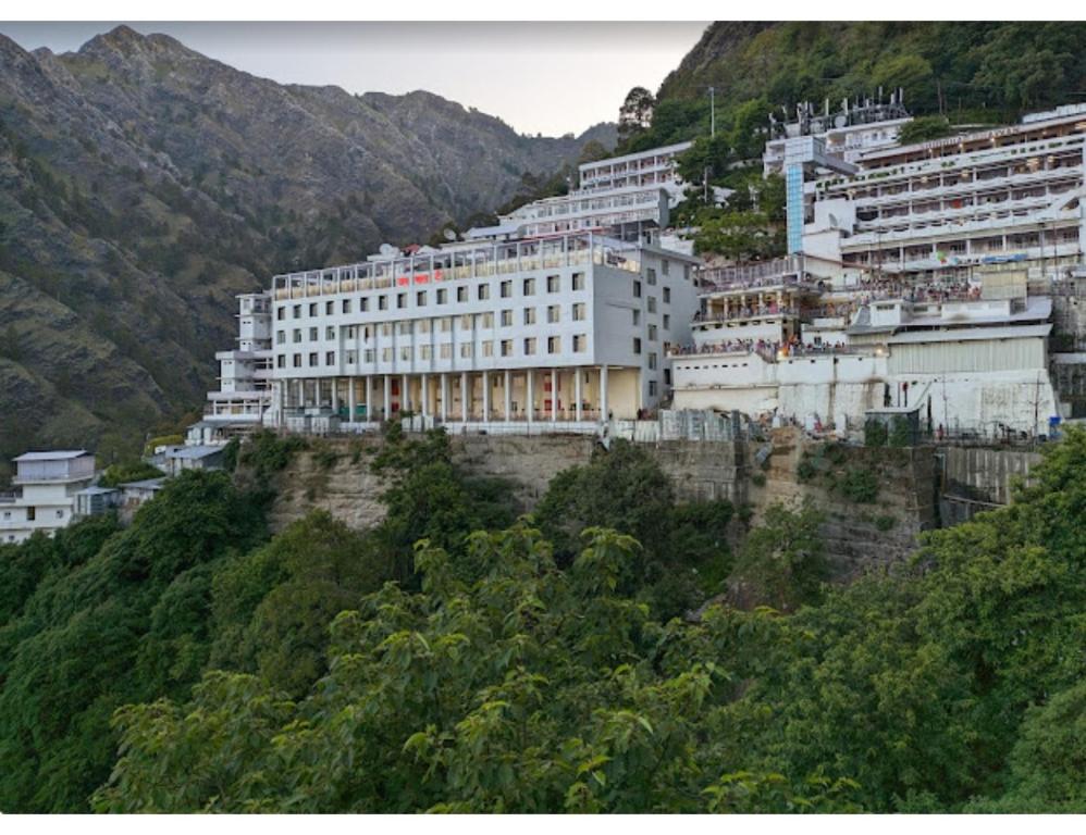 un bâtiment sur le côté d'une montagne dans l'établissement Hotel Shivaahana Residency, Katra, à Katra