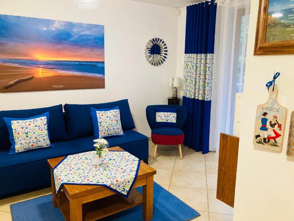 a living room with a blue couch and a table at Apartament Gęsie Piórko in Jastrzębia Góra