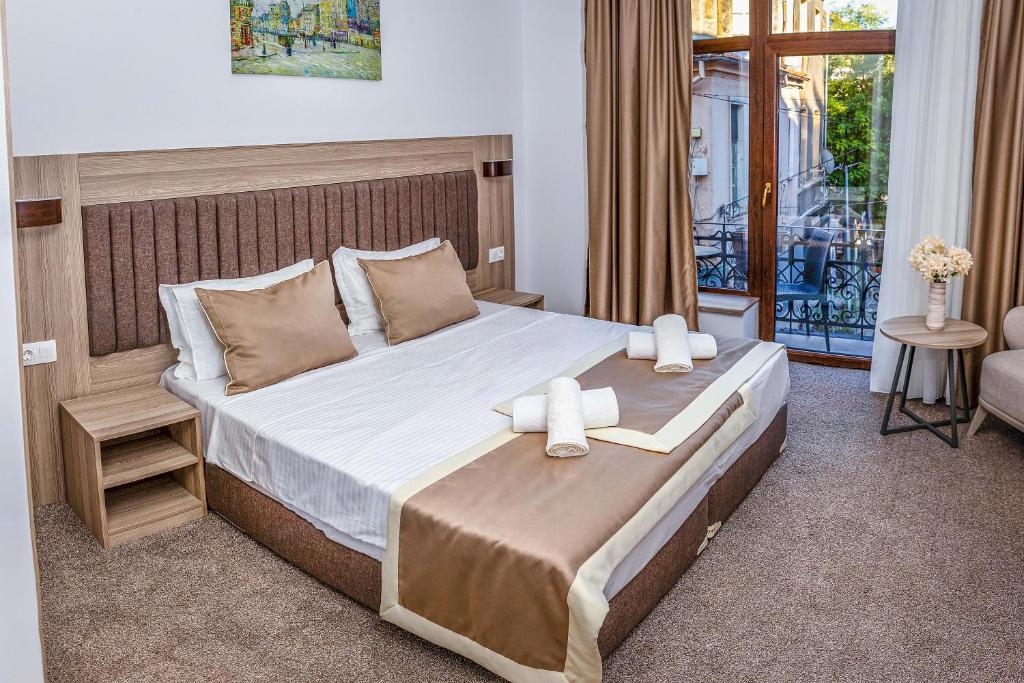 sypialnia z dużym łóżkiem z dwoma ręcznikami w obiekcie Evelin Deluxe House w Płowdiwie