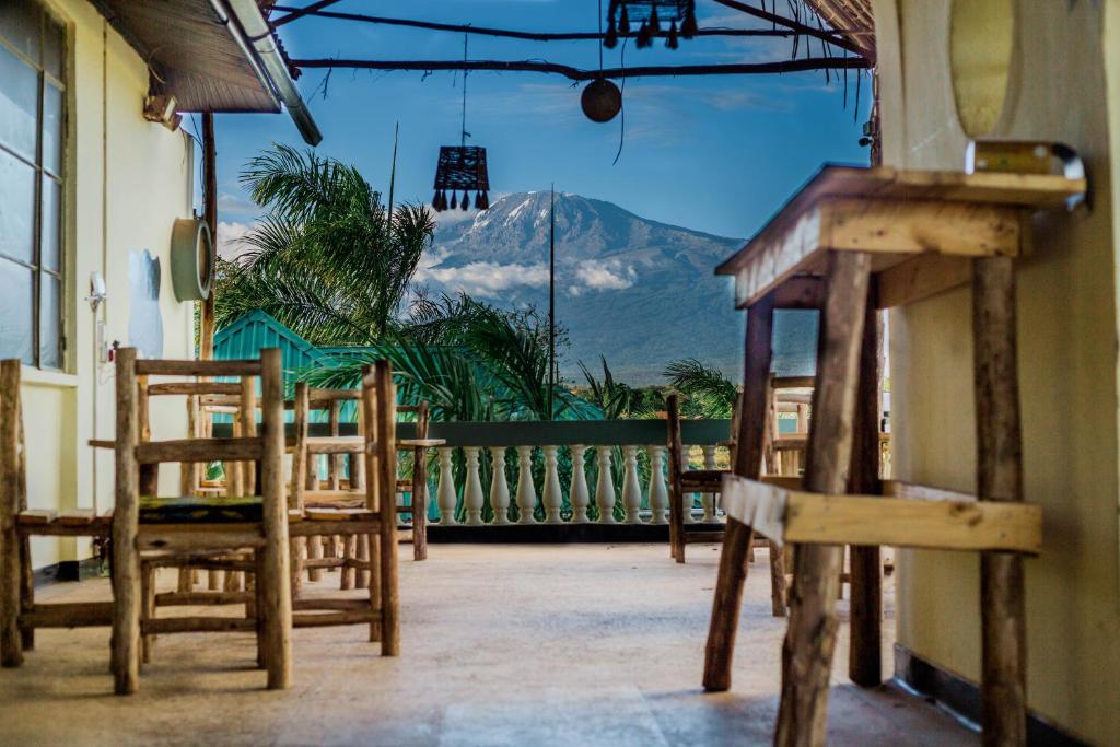 uma varanda com cadeiras e vista para uma montanha em Hill View Garden Hotel em Moshi