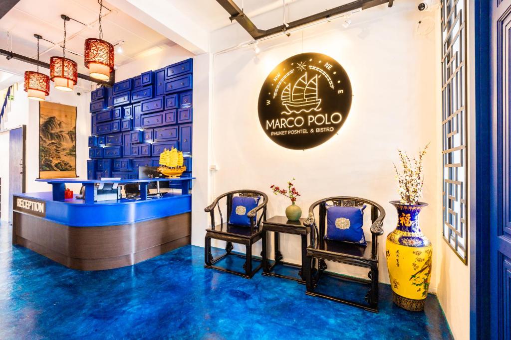 a lobby with blue floors and a sign that reads wisma at Marco Polo Phuket Poshtel & Bistro in Phuket