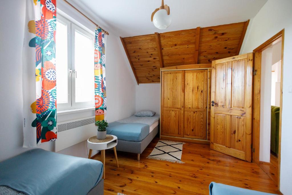 ロビにあるHoliday home Jarzębinowaのベッドと窓が備わる小さな客室です。