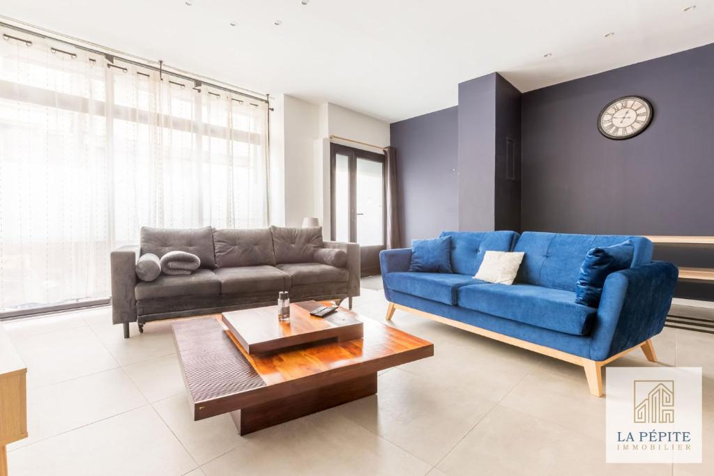 un salon avec un canapé bleu et une table dans l'établissement Atelier 46 - Appartement 2 chambres., à Valenciennes