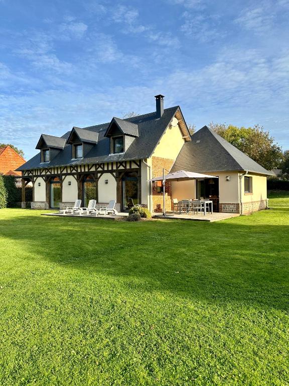 une grande maison avec une pelouse devant dans l'établissement LE CLOS DES GRANGES, à Quiberville