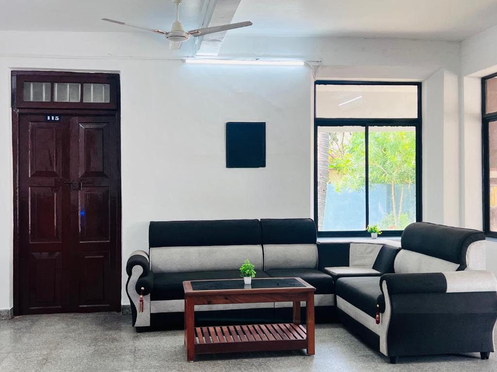 a living room with a couch and a table at Hotel Sunday - Townhouse Club Airport Trivandrum in Trivandrum