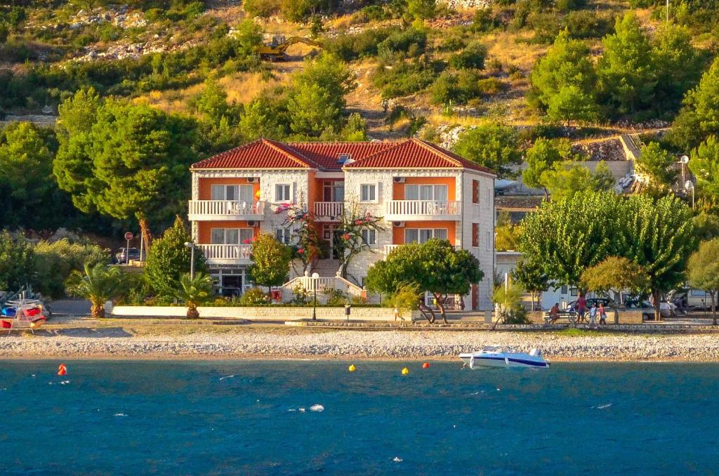 a house on the shore of a body of water at Apartments Villa Iva in Orebić