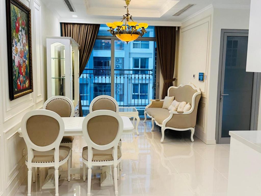 a dining room with a white table and chairs at Vinhomes Landmark 81 in Ho Chi Minh City