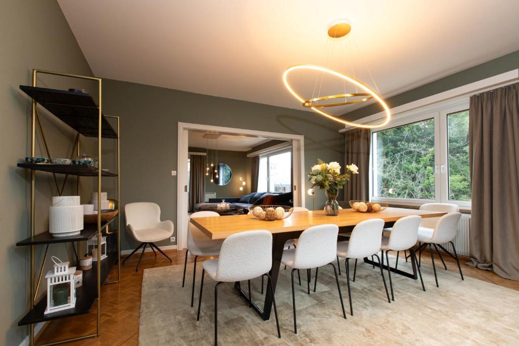 a dining room with a table and white chairs at La VILLA du Reims in Colmar