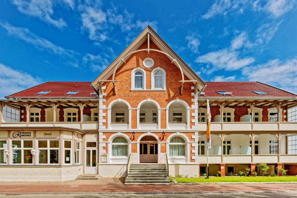 ein großes Backsteingebäude mit rotem Dach in der Unterkunft Hotel Störtebeker in Graal-Müritz