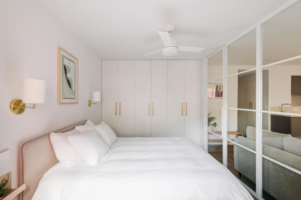 a white bedroom with a bed and a couch at BEAUTIFUL APARTMENT IN THE HEART OF MADRID in Madrid