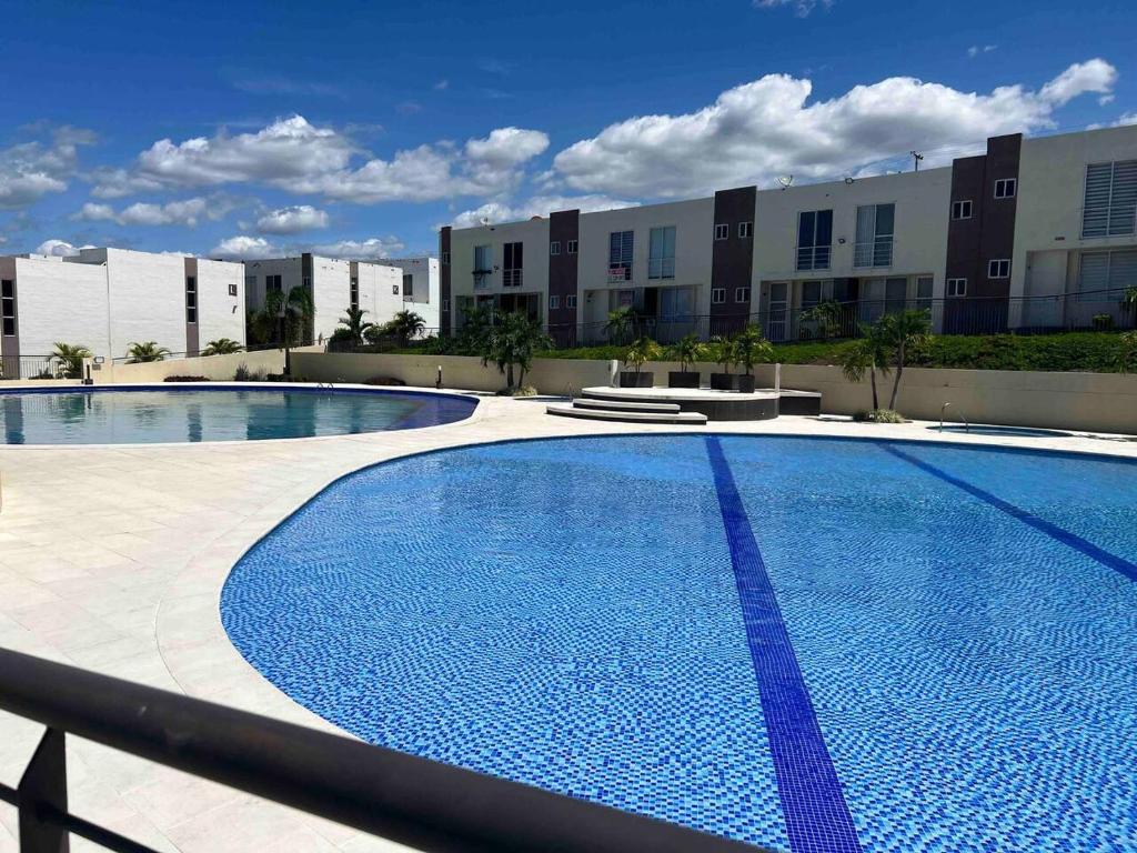 a large swimming pool in front of a building at Cómoda casa en condominio para descansar in Ricaurte
