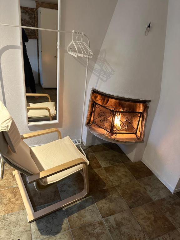a room with a chair and a fireplace at Room B in Malmö