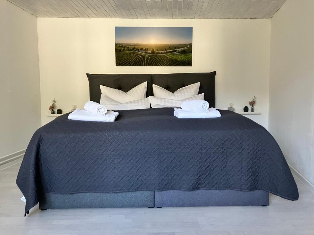 una camera da letto con un grande letto blu con cuscini bianchi di Guesthouse - Guntersblum a Guntersblum