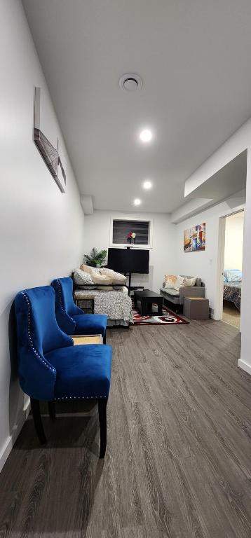 een woonkamer met een blauwe stoel en een bank bij Glowaide Place in Winnipeg