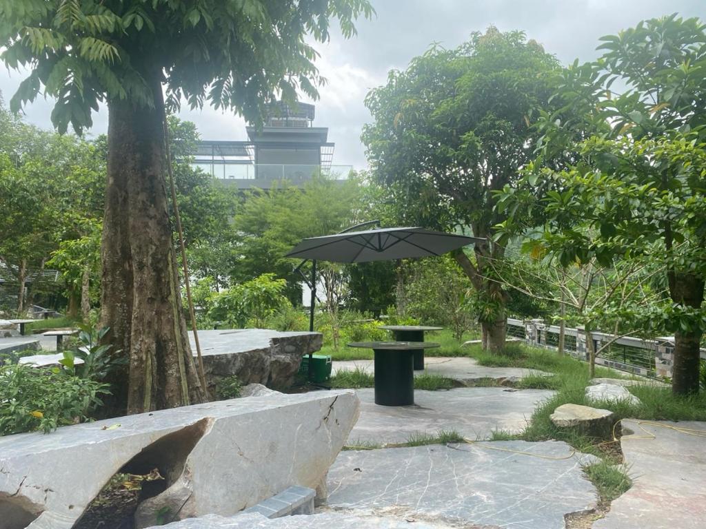 um parque com uma mesa e um guarda-chuva em Homestay ties em Ha Giang