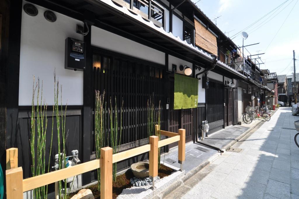 een gebouw met een hek naast een straat bij Wakakusa-an in Kyoto
