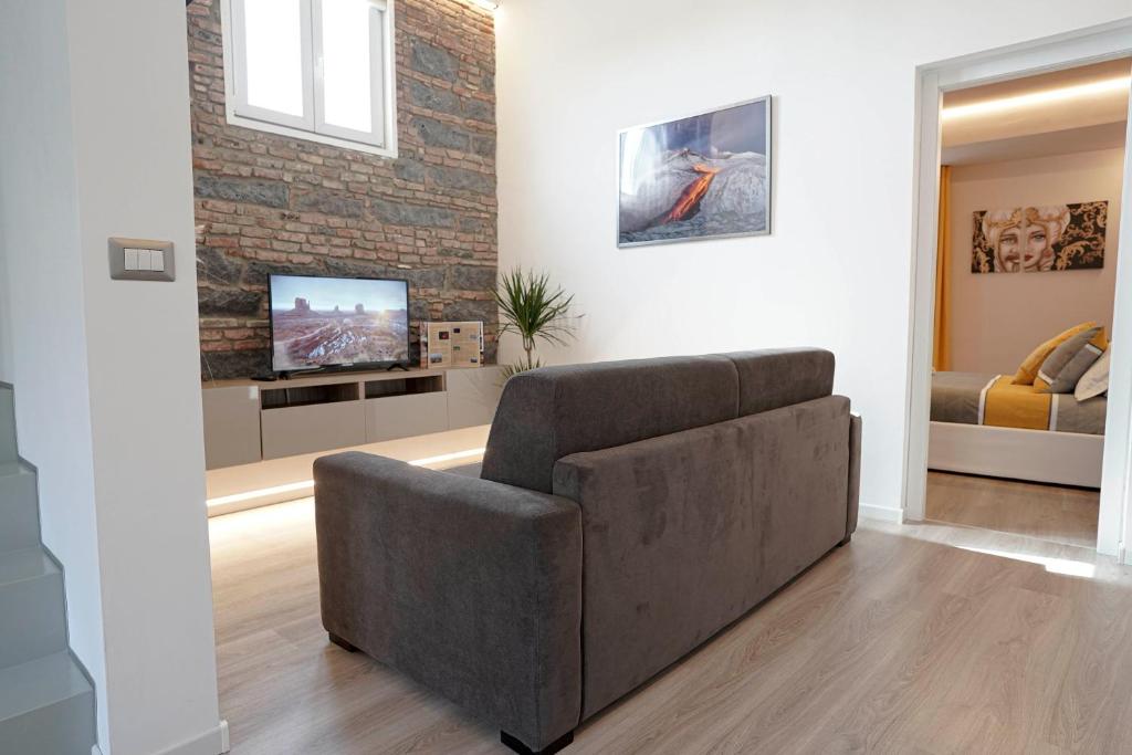 ein Wohnzimmer mit einem Sofa und einem TV in der Unterkunft Domus 25 in Catania