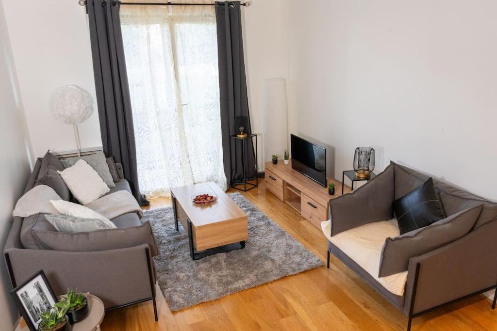 ein Wohnzimmer mit 2 Sofas und einem TV in der Unterkunft Appartement entier à louer in Villiers-sur-Marne