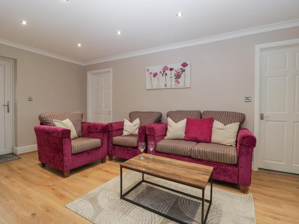 a living room with two couches and a coffee table at Myrtle Cottage in Cardiff