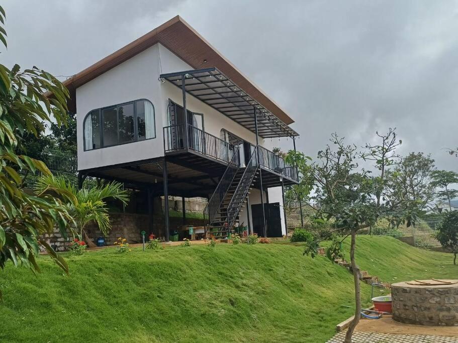 een groot huis met een balkon op een heuvel bij The FARM on the LAKE in Di Linh