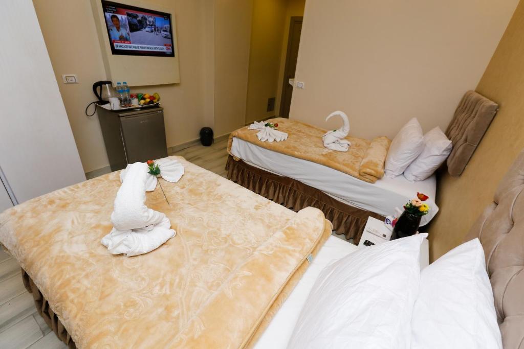a hotel room with two beds with towels on them at Venus Pyramids Inn - Top Roof Access W Free Break Fast in Cairo