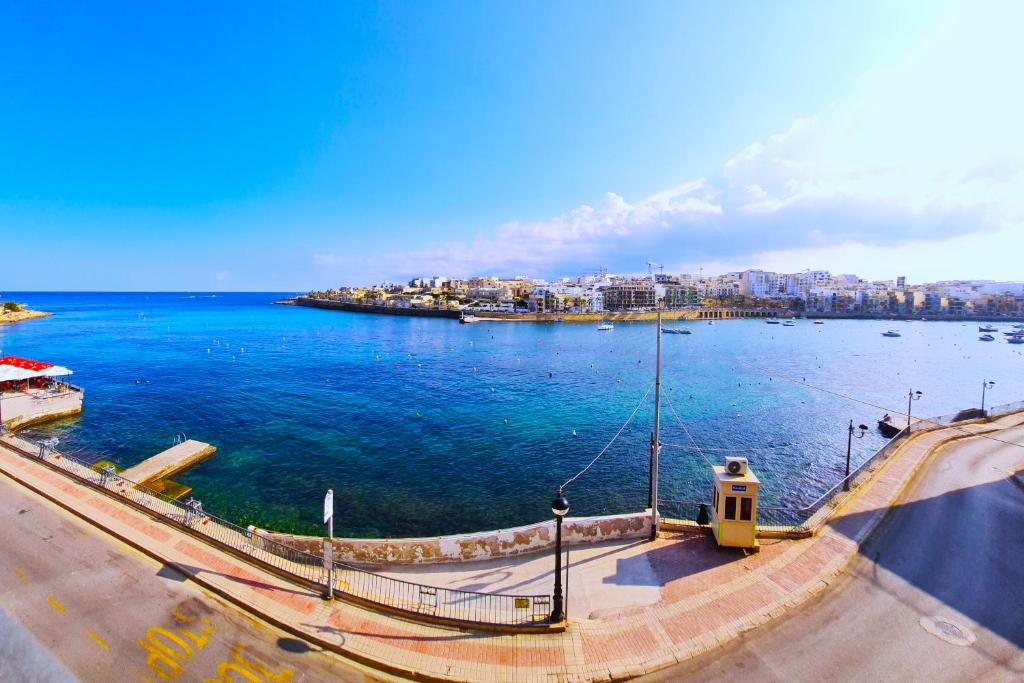 vista su una grande cassa d'acqua con città di Unobstructred seaviews, 2BR, Kingbeds, Fully ACd a Marsaskala