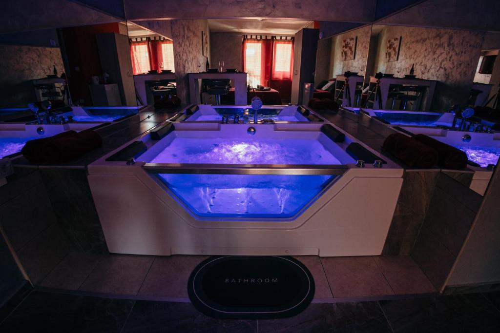 d'un bain à remous dans une chambre avec éclairage bleu dans l'établissement Bordeaux City Center, à Novi Sad