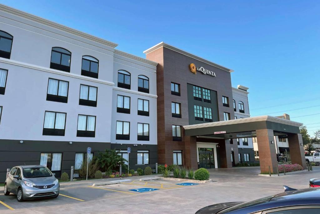 a car parked in a parking lot in front of a hotel at La Quinta Inn & Suites by Wyndham Tulsa Midtown in Tulsa