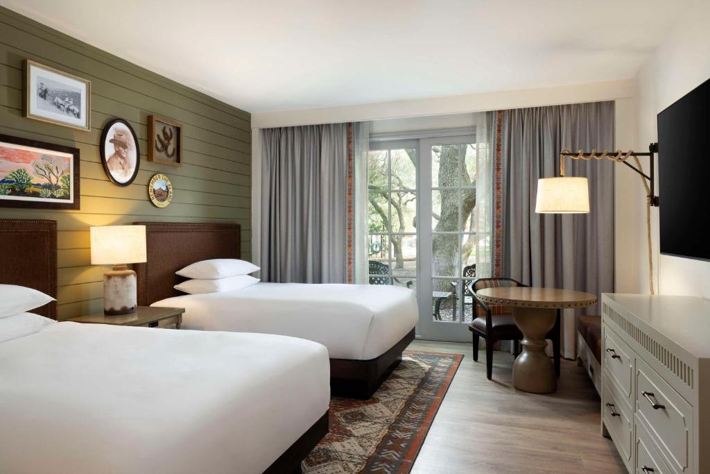 a hotel room with two beds and a table at Hyatt Regency Hill Country Resort & Spa in San Antonio