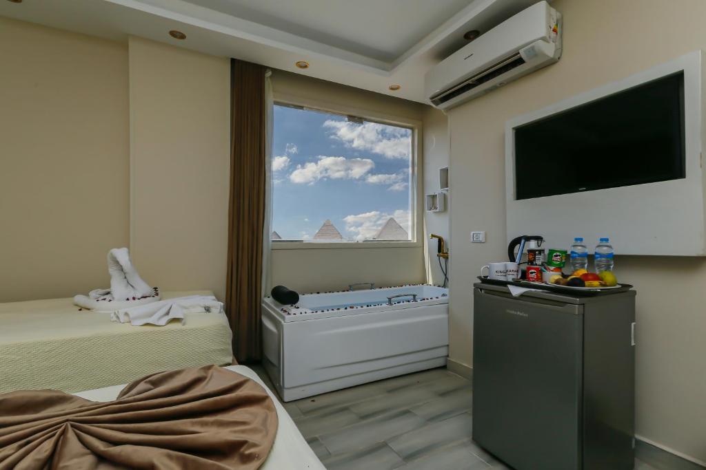 a hotel room with a bed and a large window at Venus Pyramids Inn - Top Roof Access W Free Break Fast in Cairo