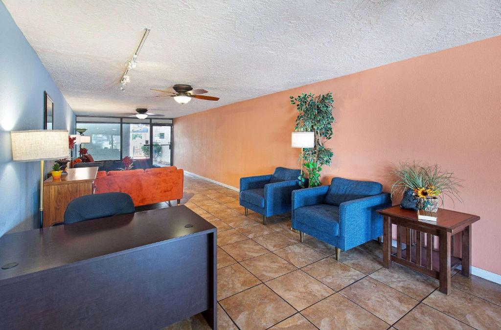 a waiting room with blue chairs and a table at Americana Inn a Travelodge by Wyndham in Pigeon Forge