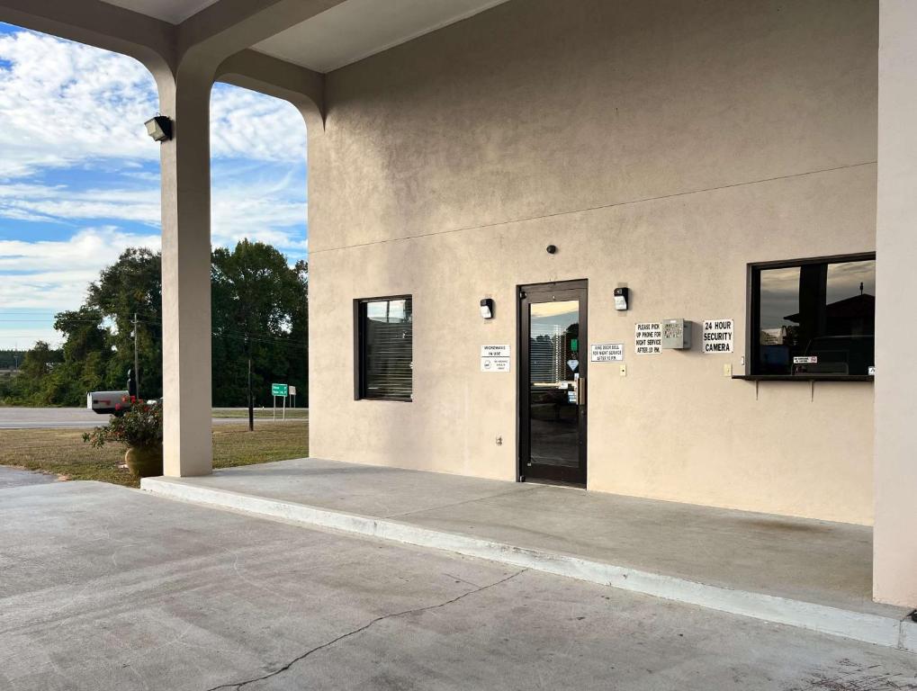 a building with a revolving door and a door to a parking lot at Motel 6 Abbeville, AL in Abbeville
