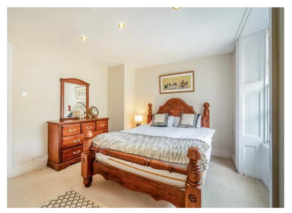 1 dormitorio con cama, tocador y espejo en 8 bedroom Annexe at Moulton Grange, en Northampton