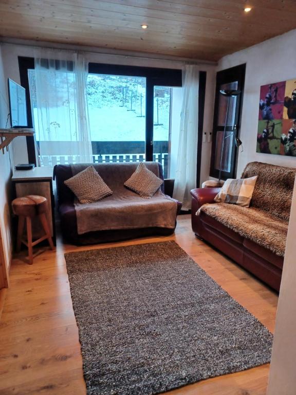 ein Wohnzimmer mit einem Sofa und einem Tisch in der Unterkunft Le Fayard in Arâches-la-Frasse