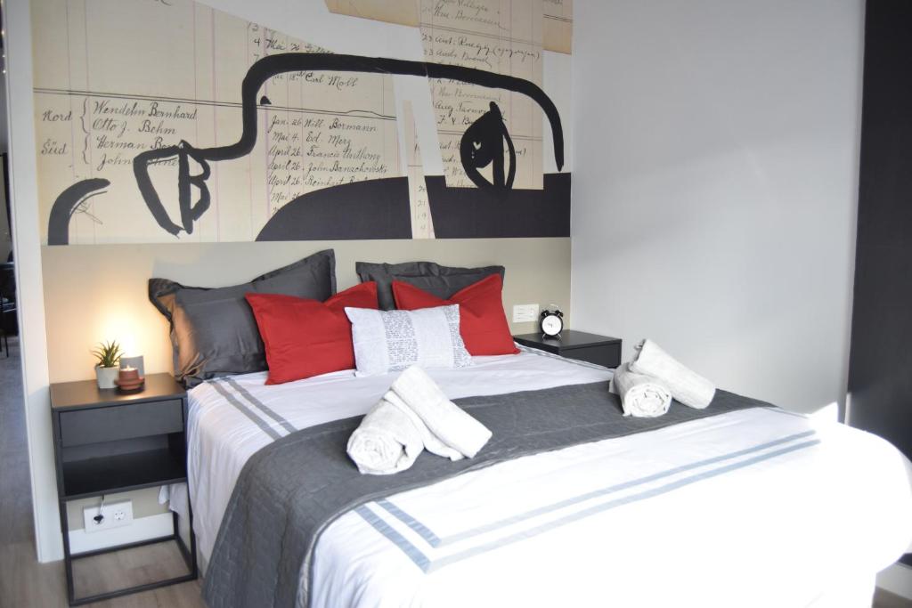 - une chambre avec un grand lit et des oreillers rouges dans l'établissement RESIDENCIAL ALCOY Apartahotel, à Alcoy