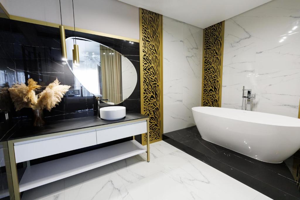 a bathroom with a white tub and a sink at Villa Grey Hotel in Duliby