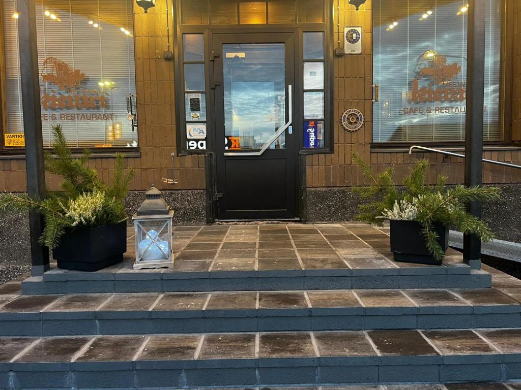 a front door of a building with potted plants at Hotel Mestarin Kievari in Kemijärvi