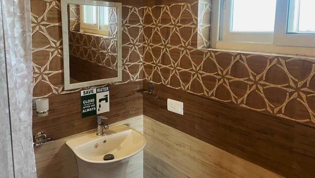 a bathroom with a sink and a mirror at Casa Letibunga in Mukteswar