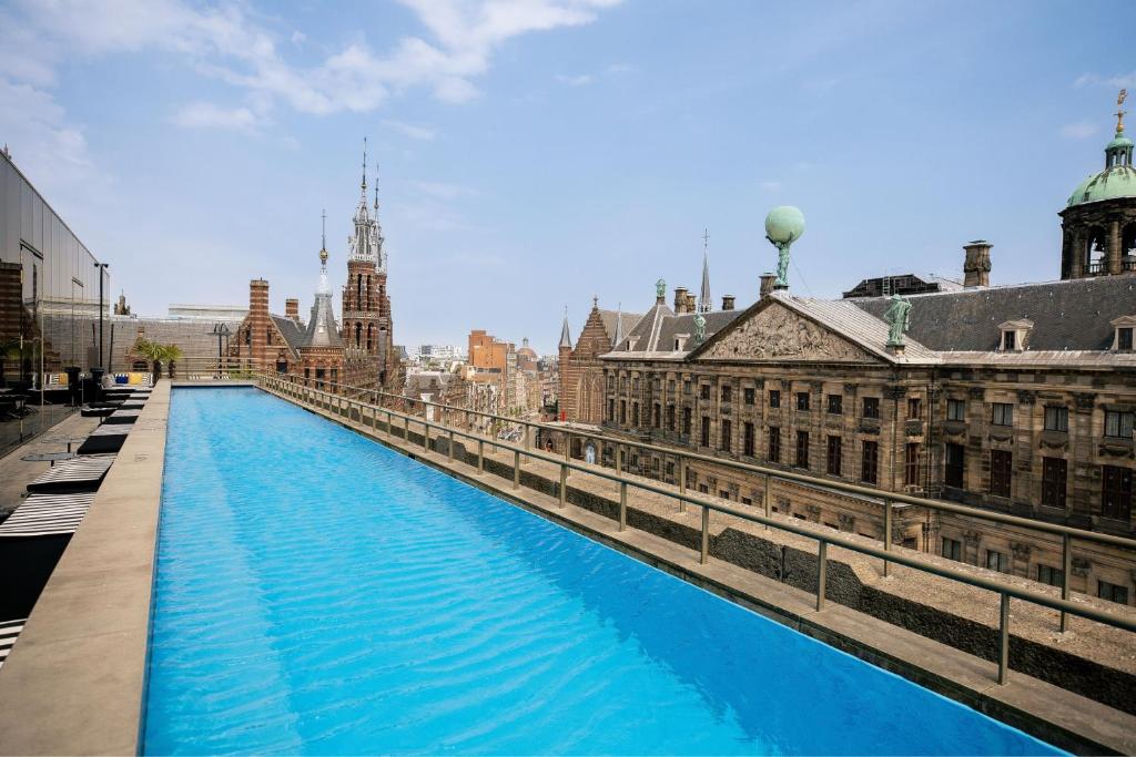 een lang blauw kanaal in een stad met gebouwen bij W Amsterdam in Amsterdam