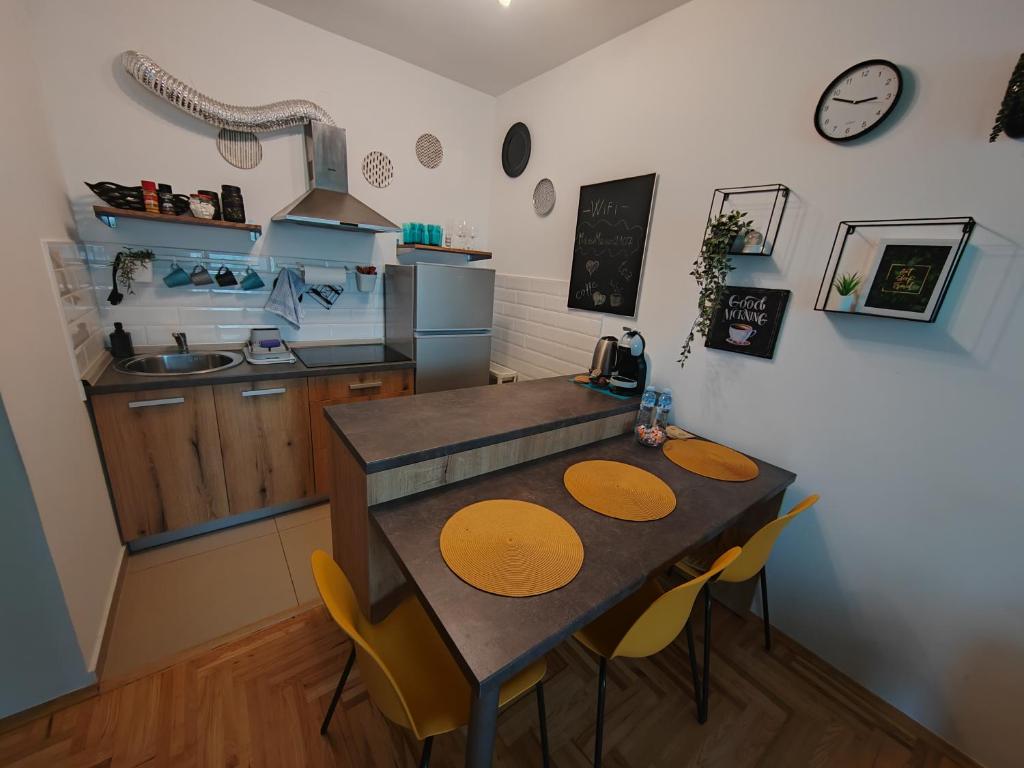 a kitchen with a table and chairs in a room at Krstić_lux apartman in Subotica