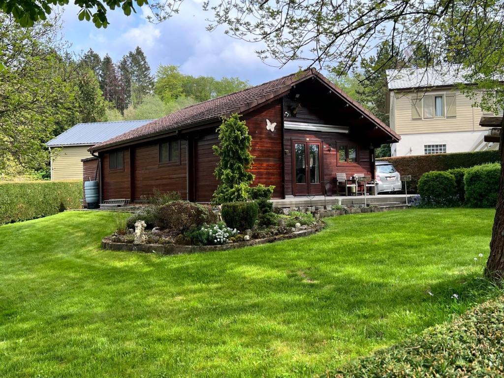 a log cabin with a yard in front of it at Chalet 't Musje in Durbuy