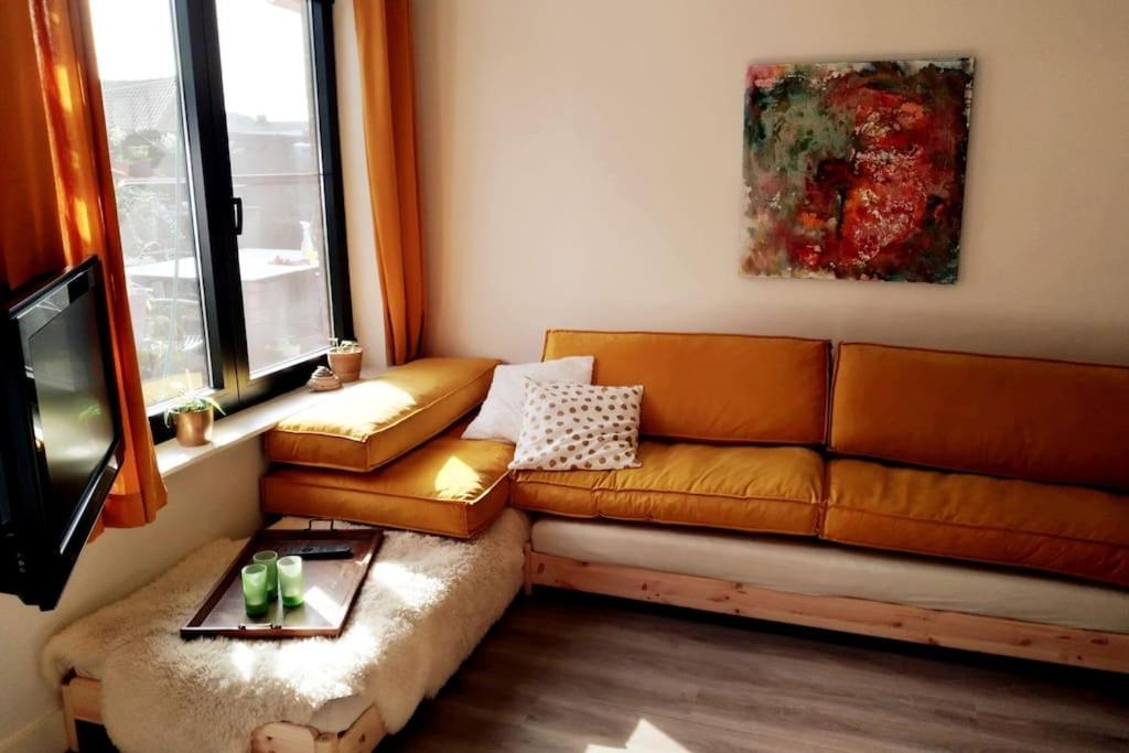 uma sala de estar com um sofá e uma televisão em LodgeRivierenhof em Antuérpia