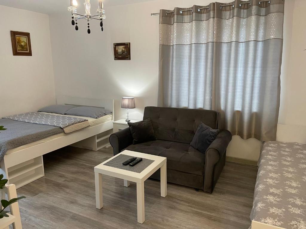 Sala de estar con sofá, cama y mesa en NONIEWICZA CENTRUM, en Suwałki