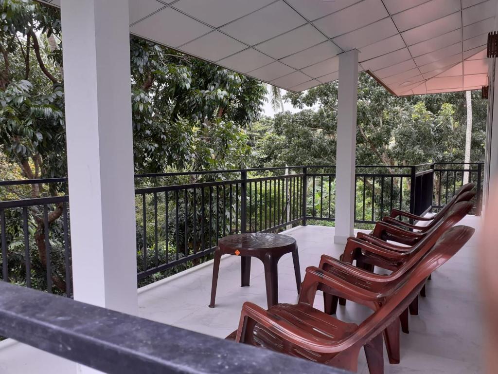 a row of chairs and a table on a porch at VILLA GREEN VILLAGE in Kamburugamuwa