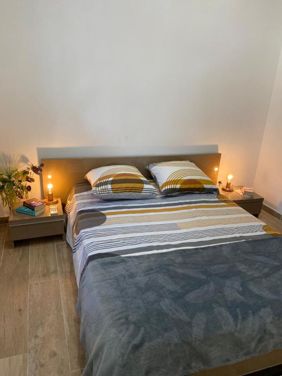 - une chambre avec un grand lit et 2 tables de chevet dans l'établissement Appartement chic plage des Catalans, à Marseille